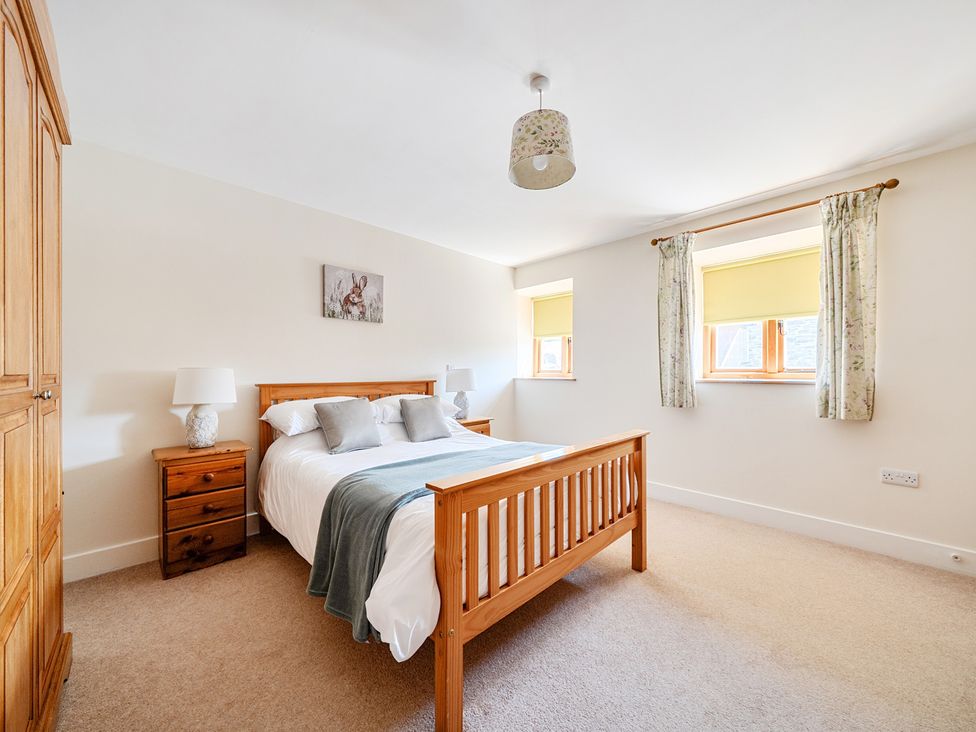 A bedroom with a bed and bedside tables at The Dairy in Corwen
