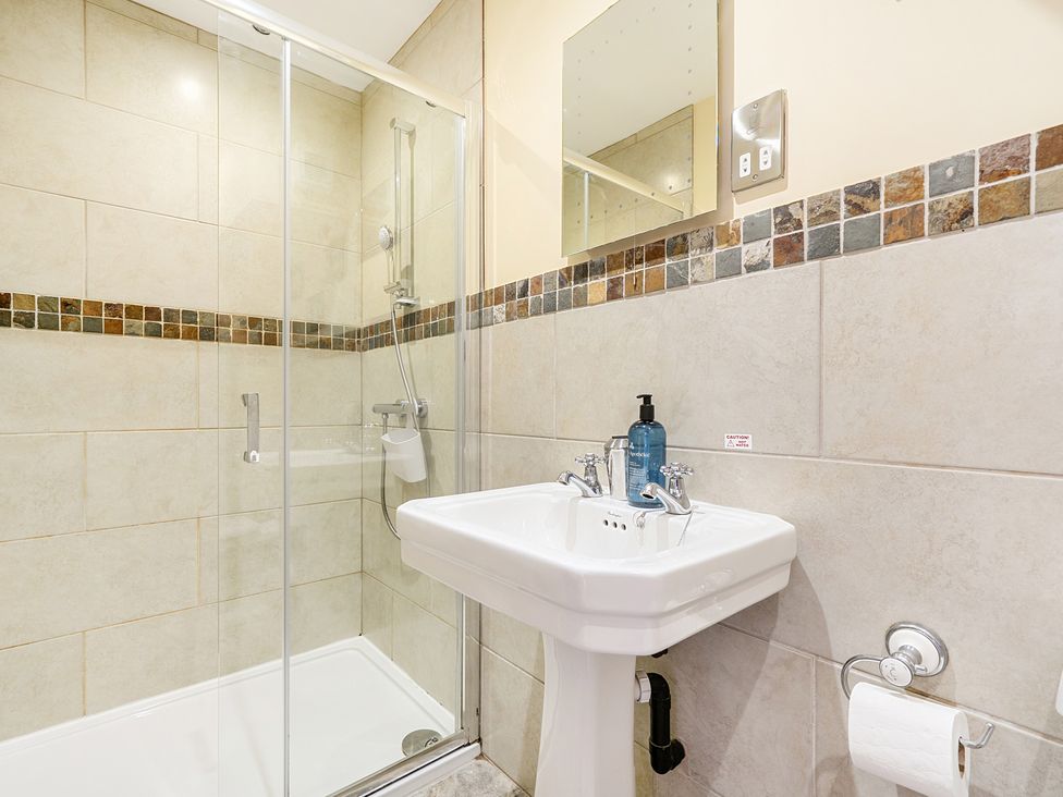 A bathroom with a wash basin and shower at The Dairy in Corwen