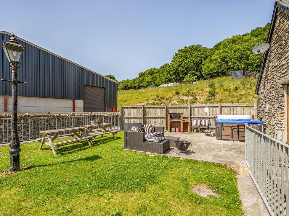 An outdoor garden with seating and a hot tub at The Dairy in Corwen