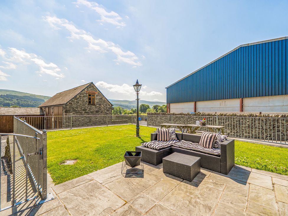 A garden with outdoor furniture and a lamp post at The Dairy in Corwen