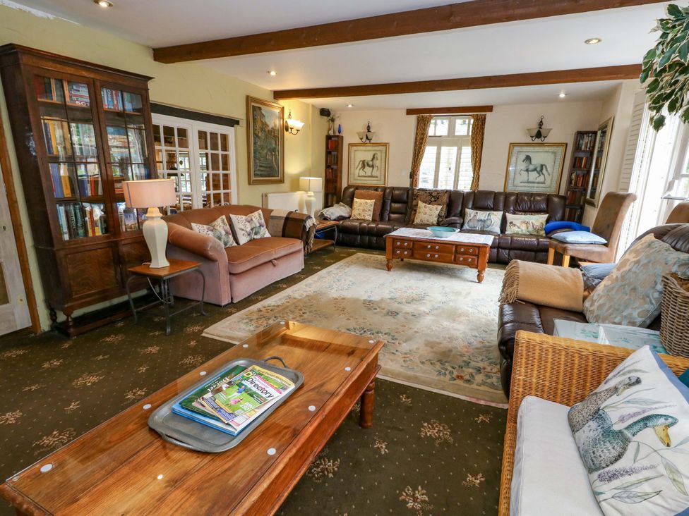A living room with a bookshelf and couches at Piddle Inn in Piddletrenthide