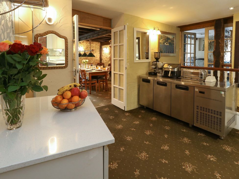 A kitchen with fruit bowl and roses on the counter at Piddle Inn in Piddletrenthide