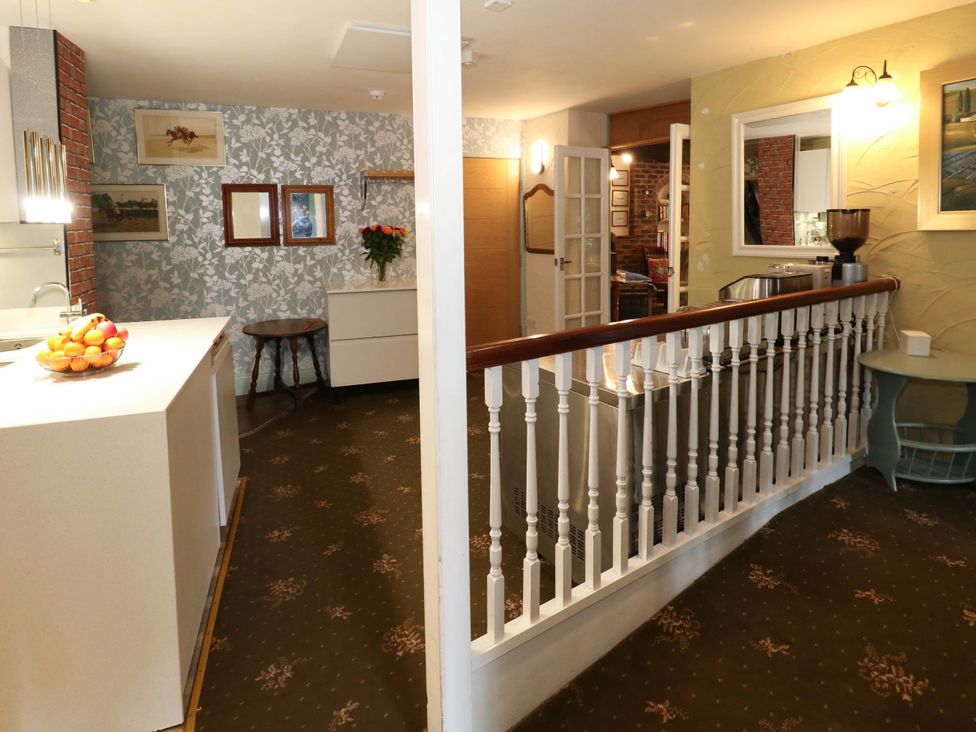 An entrance hall with a railing and kitchen area at Piddle Inn in Piddletrenthide