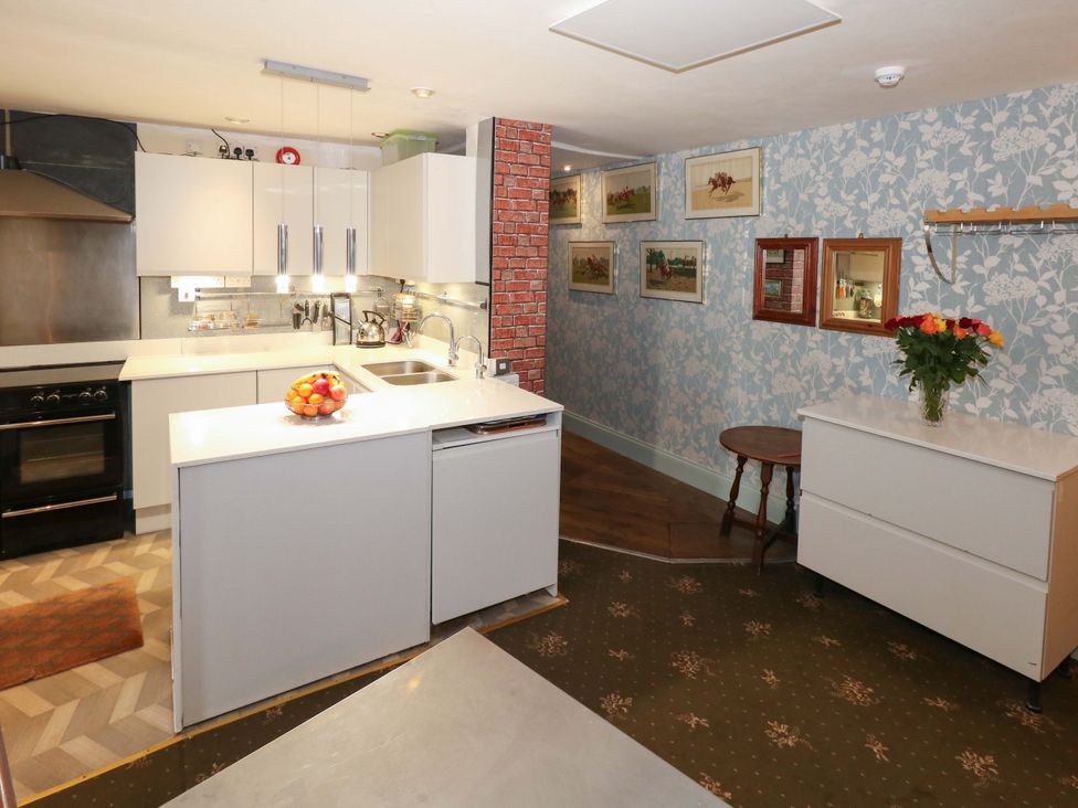 A kitchen with cabinets, sink, and utensils at Piddle Inn in Piddletrenthide