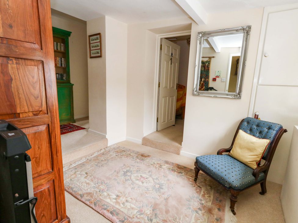 A hallway with a chair and a mirror at Piddle Inn in Piddletrenthide