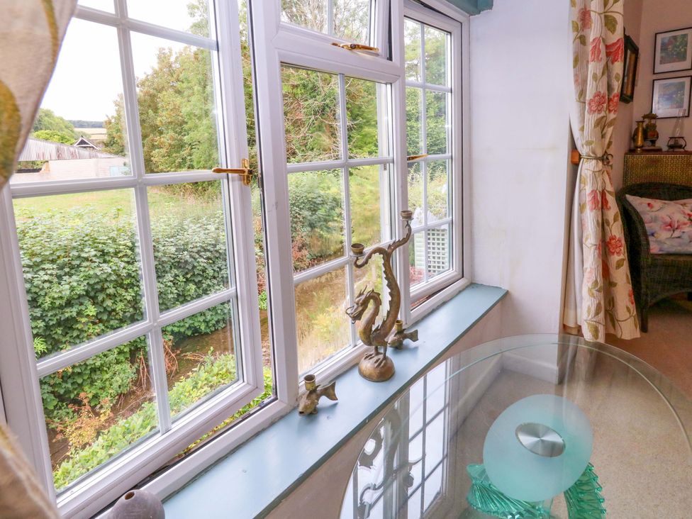 A living room with windows and a decorative figurine at Piddle Inn in Piddletrenthide