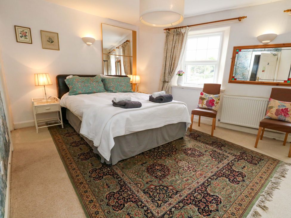 A bedroom with a bed and chairs at Piddle Inn in Piddletrenthide