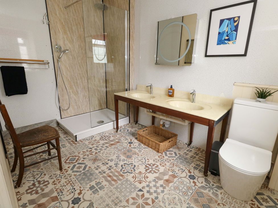 A bathroom with a shower and double sinks at Piddle Inn in Piddletrenthide