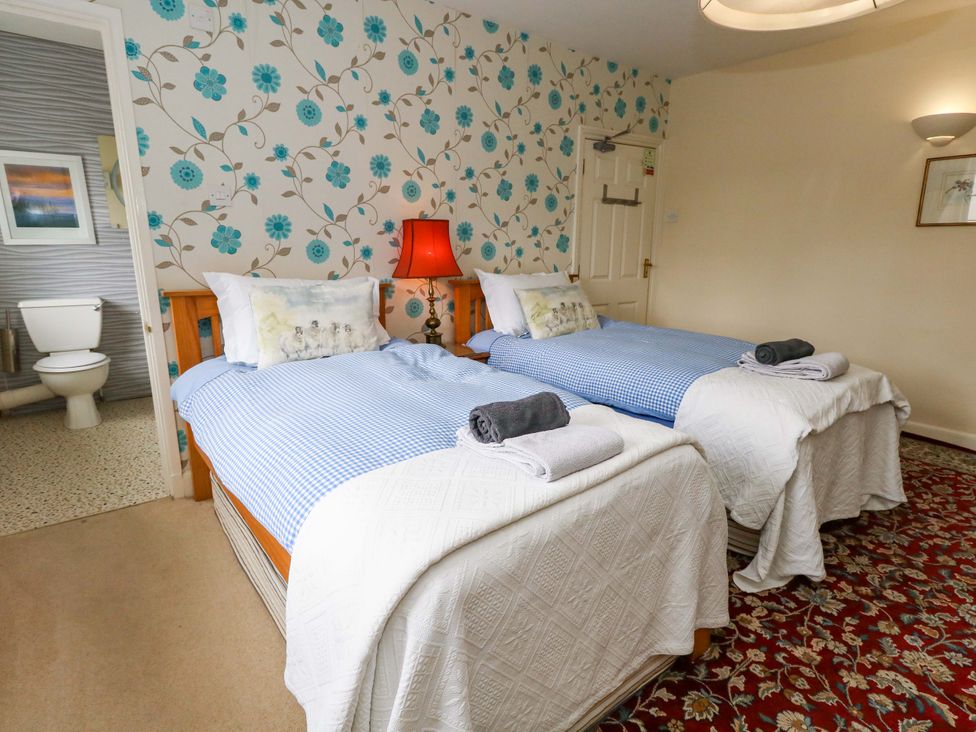 A bedroom with two beds and a lamp at Piddle Inn Piddletrenthide