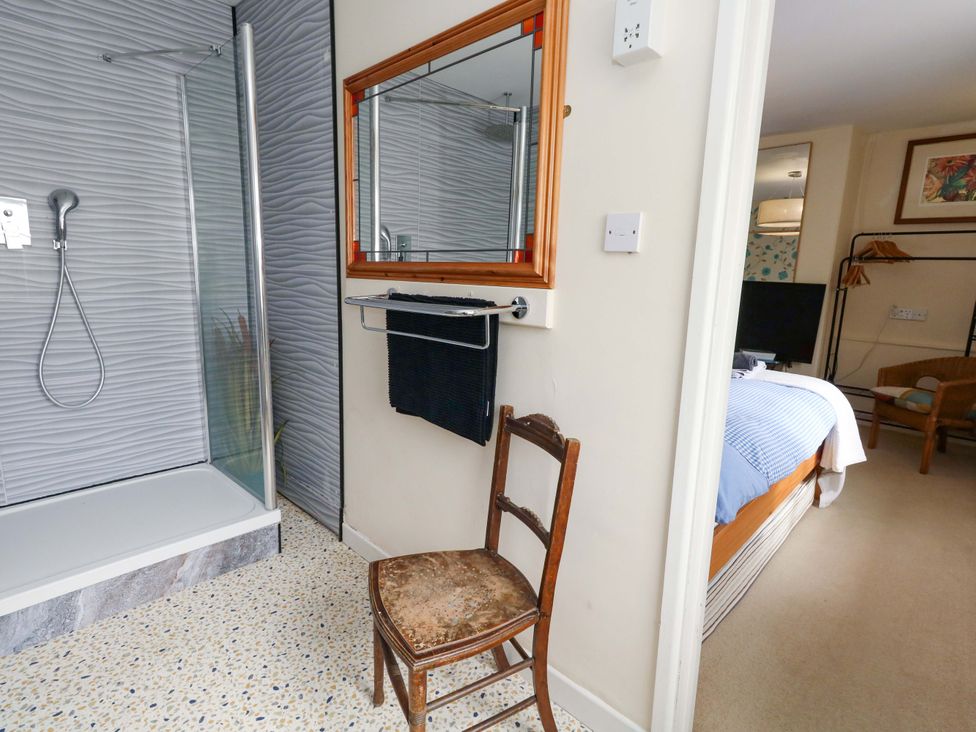 A bathroom with a shower and a chair at Piddle Inn in Piddletrenthide