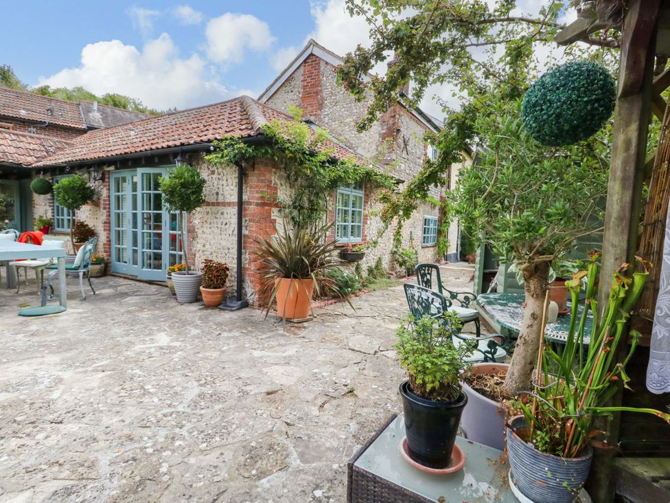 An outdoor patio with a dining table and flower pots at Piddle Inn Piddletrenthide