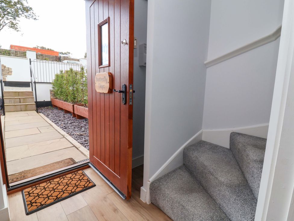 An entrance with a wooden door and stairs at Butterfly Days in Bideford