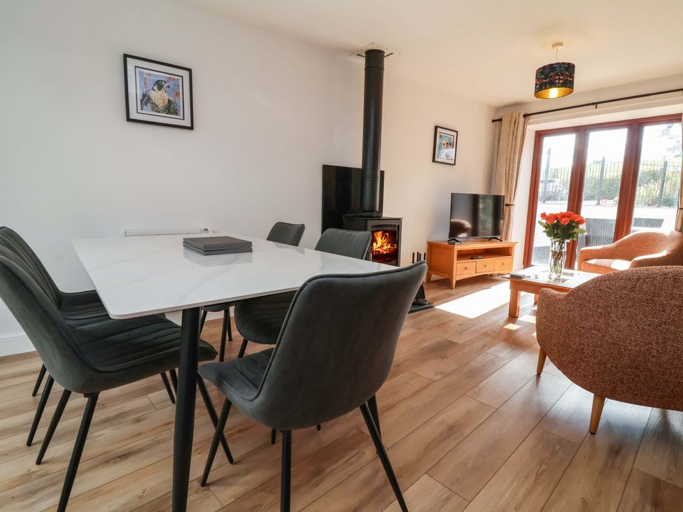 A living room with a fireplace and dining area at Butterfly Days in Bideford
