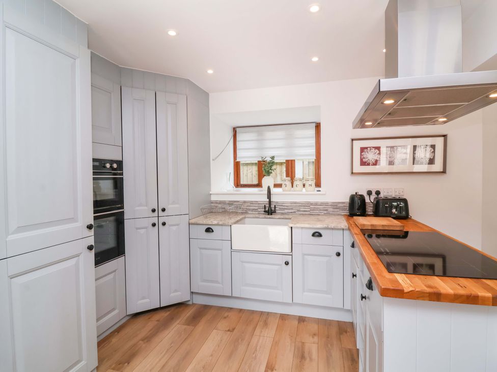 A kitchen with cabinets and appliances at Butterfly Days in Bideford