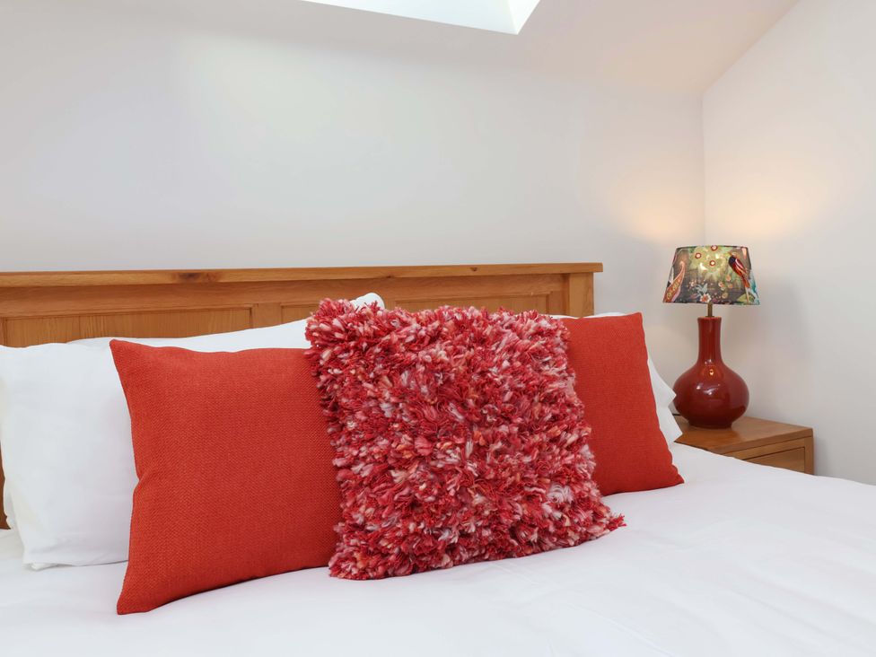 A bedroom with pillows and a lamp at Butterfly Days in Bideford