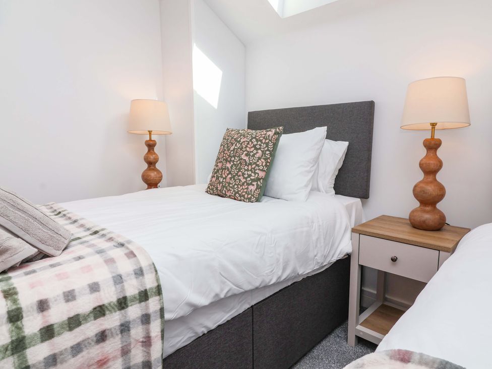A bedroom with two beds and a nightstand at Butterfly Days in Bideford