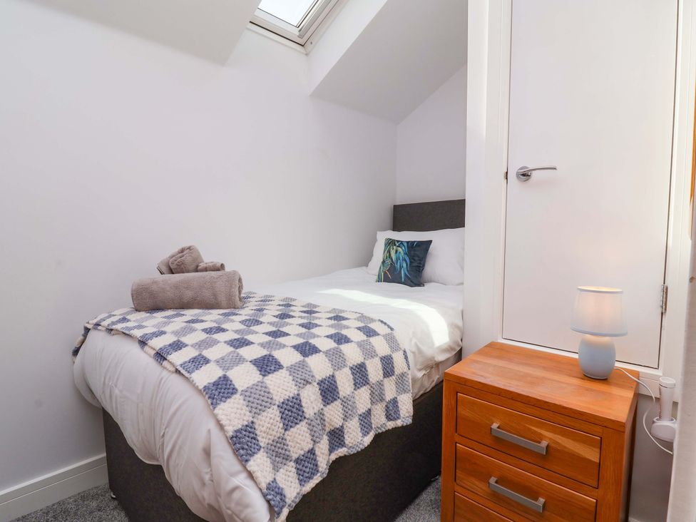 A bedroom with a bed and nightstand at Butterfly Days in Bideford