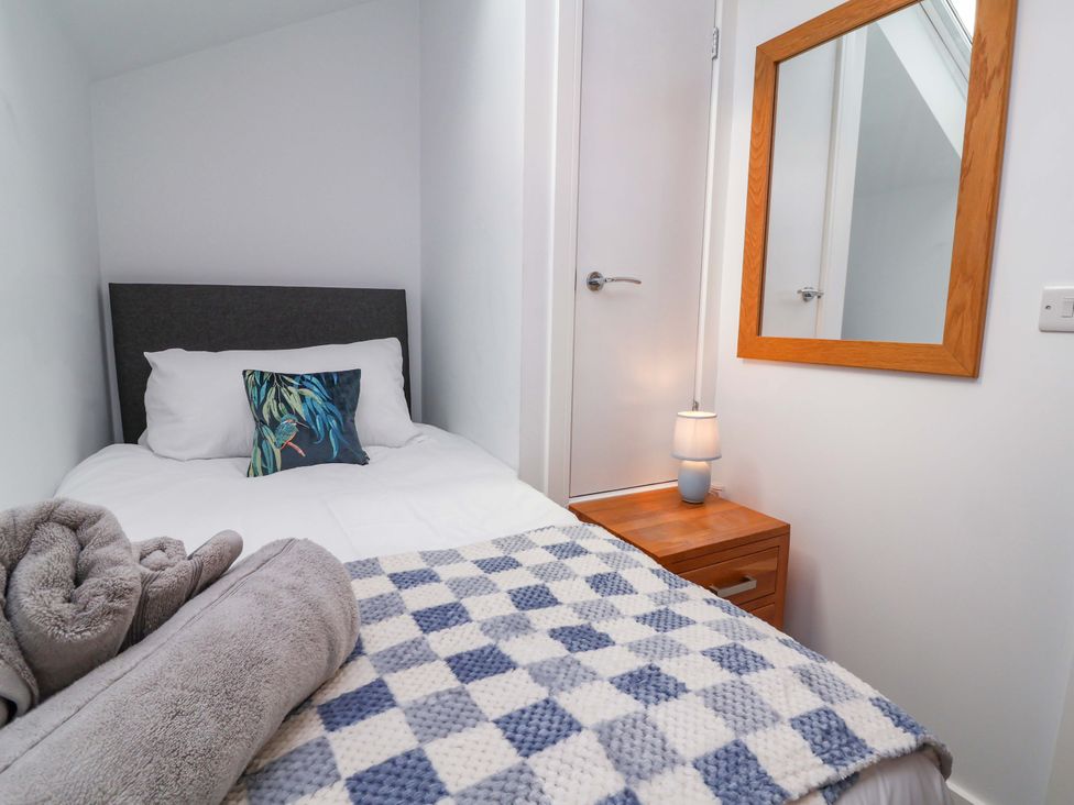 A bedroom with a single bed and a lamp at Butterfly Days in Bideford