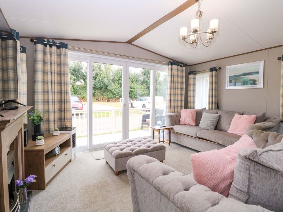A living room with a sofa and sliding doors at 17 Castle Walk in Great Yarmouth