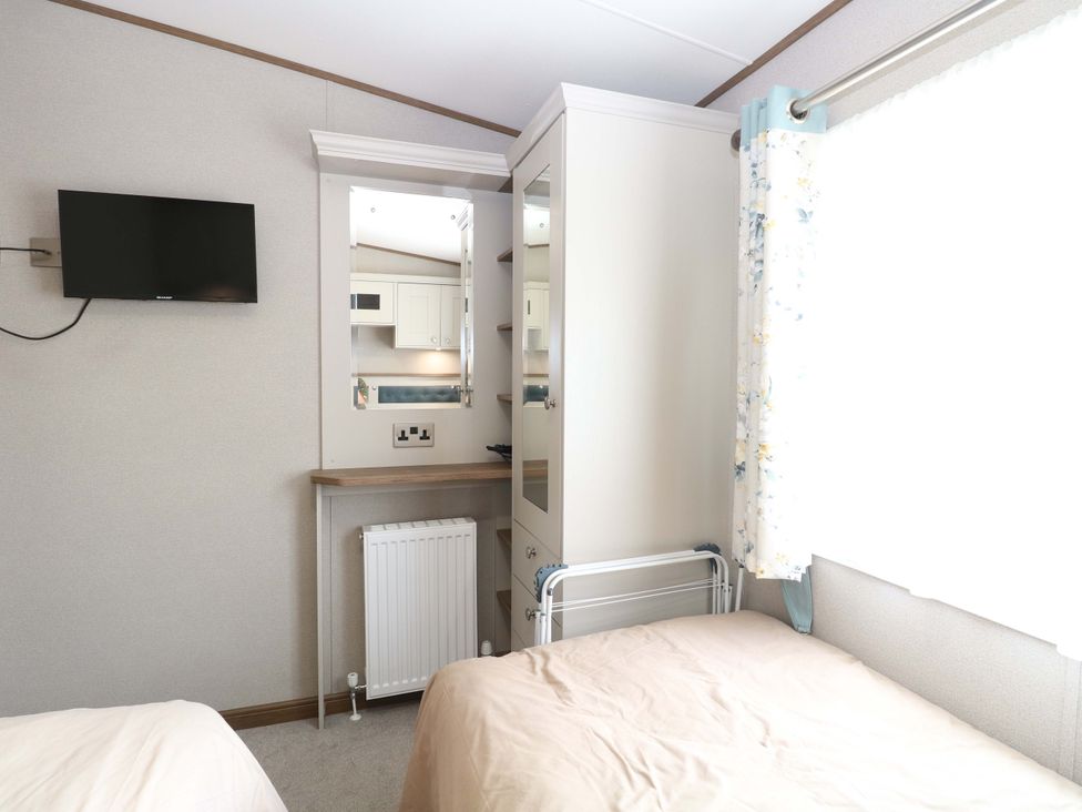 A bedroom with a television and wardrobe at 17 Castle Walk in Great Yarmouth