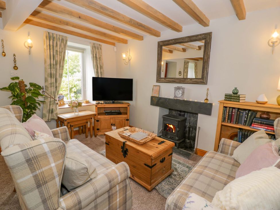 A living room with a sofa and fireplace at Brondderwen in Blaenau Ffestiniog