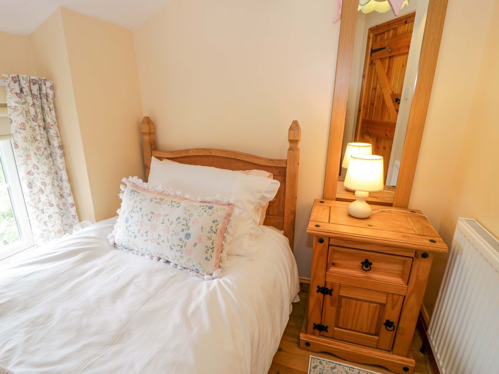 A bedroom with a bed and nightstand at Brondderwen in Blaenau Ffestiniog