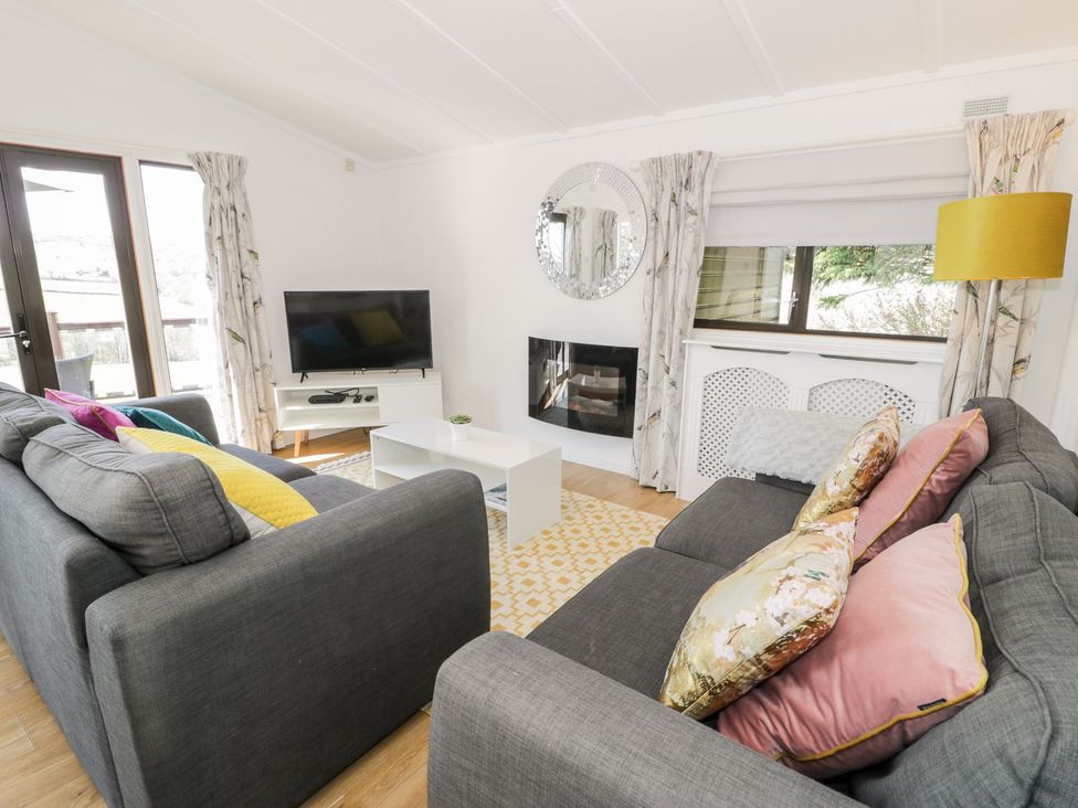 A living room with a television and a coffee table at Summertime Lodge in Rhyd-y-Foel near Abergele