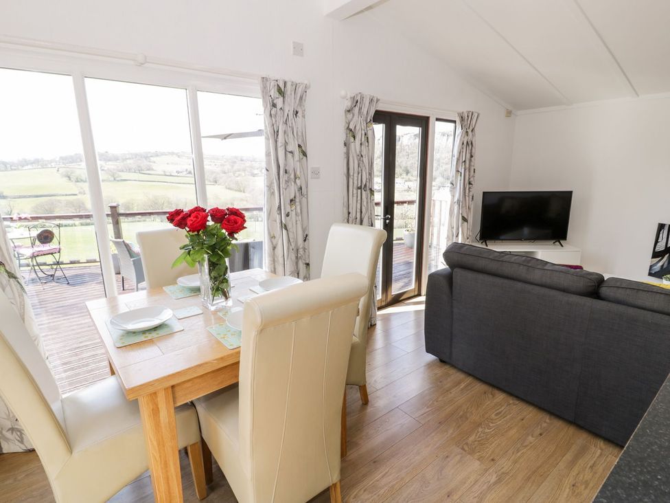 A dining room with a table and chairs at Summertime Lodge Rhyd-y-Foel near Abergele