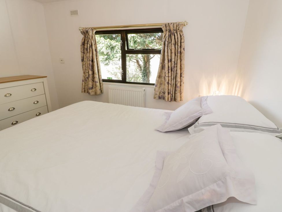 A bedroom with a bed and dresser at Summertime Lodge in Rhyd-y-Foel near Abergele