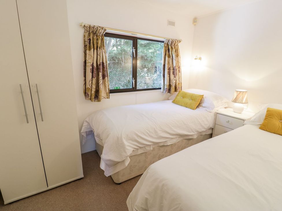 A bedroom with two beds and a window at Summertime Lodge in Rhyd-y-Foel near Abergele