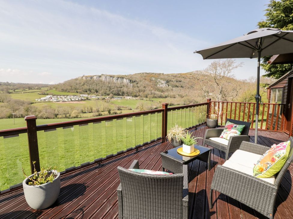 A deck area with chairs and a table at Summertime Lodge Rhyd-y-Foel near Abergele