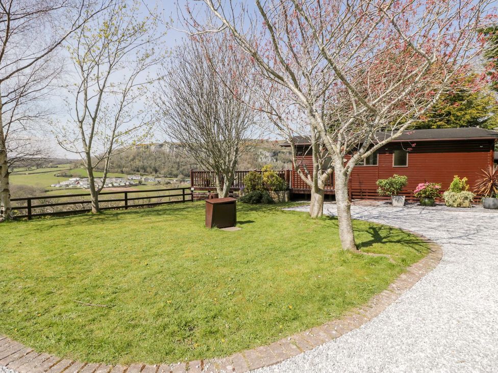 An outdoor area with trees and a lodge at Summertime Lodge Rhyd-y-Foel near Abergele