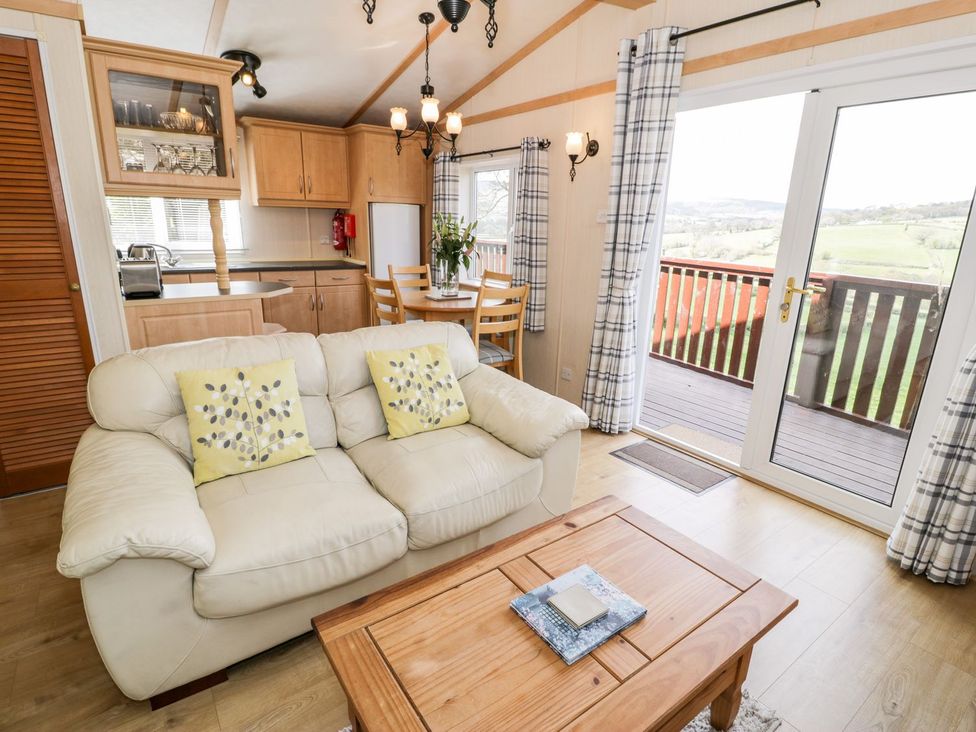 A living room with sofa and dining area at Alpine Lodge Rhyd-y-Foel near Abergele