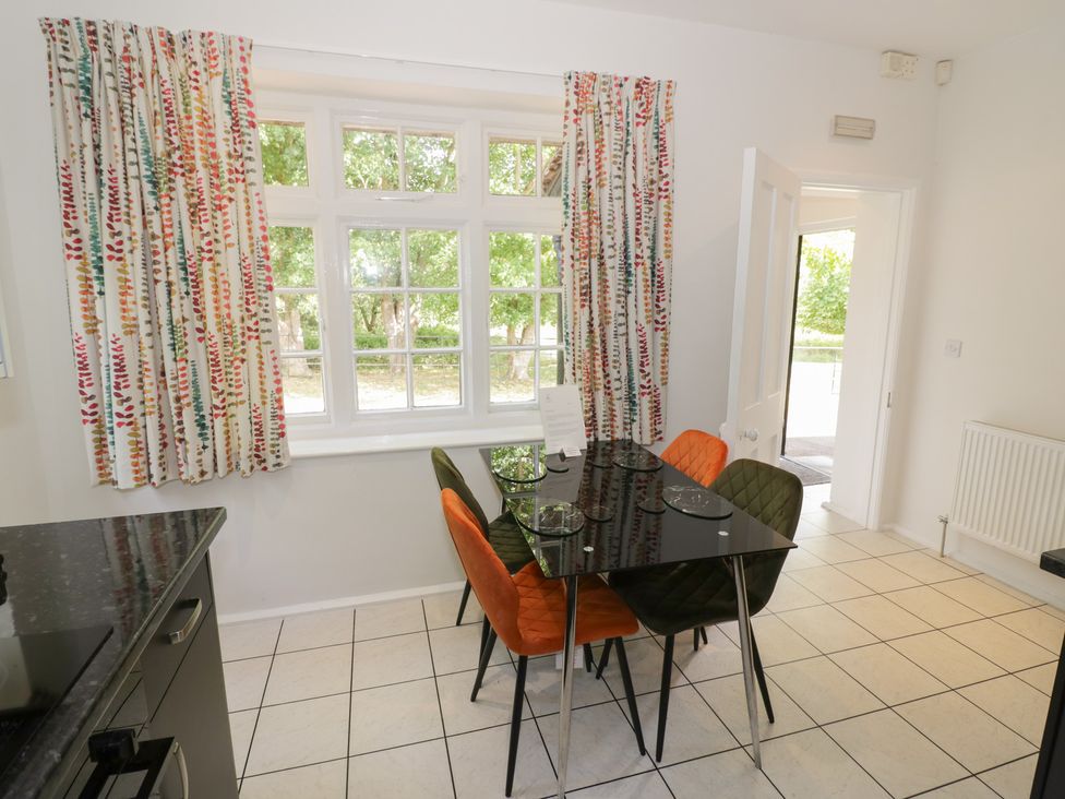 A dining room with a table and chairs at Raglan Lodge in Monmouth