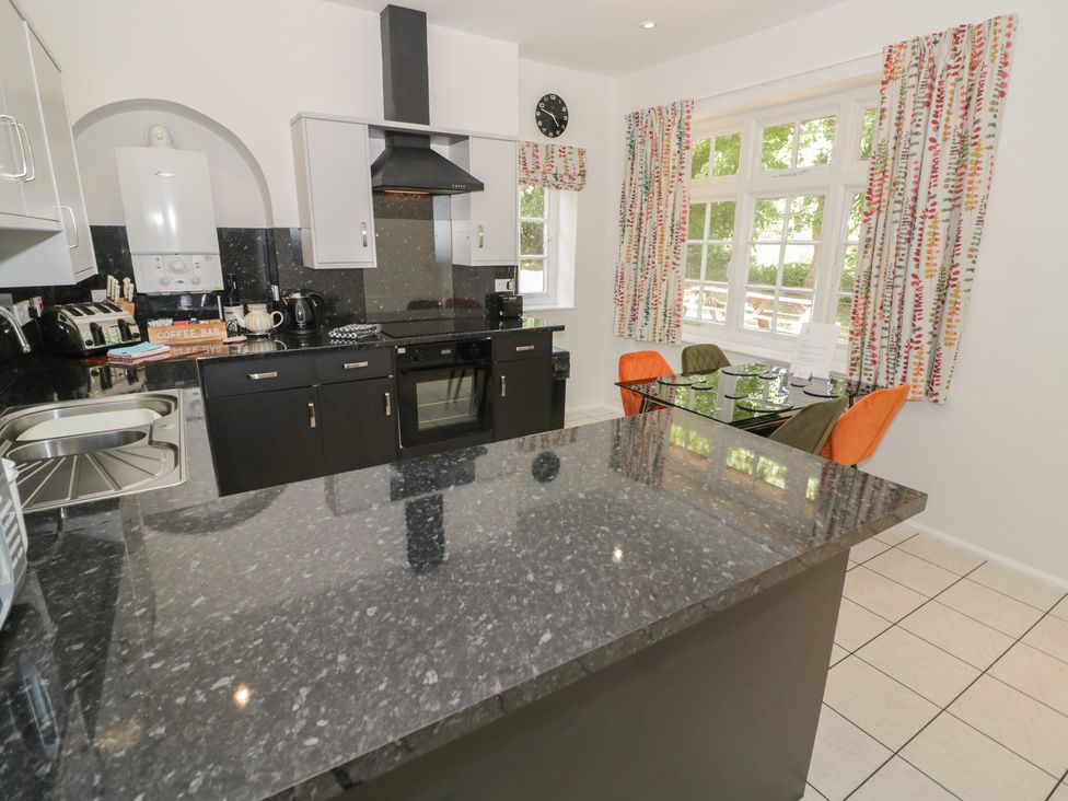A kitchen with appliances and a dining area at Raglan Lodge in Monmouth