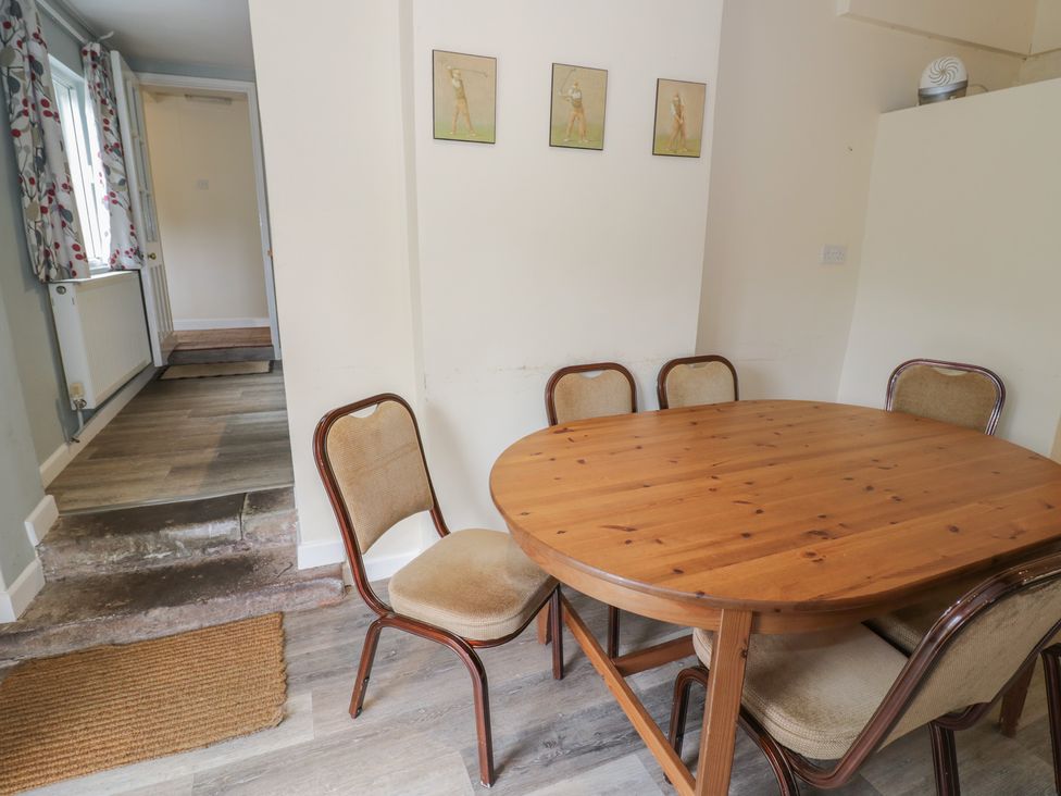 A dining room with a wooden table and chairs at Hillside Cottage