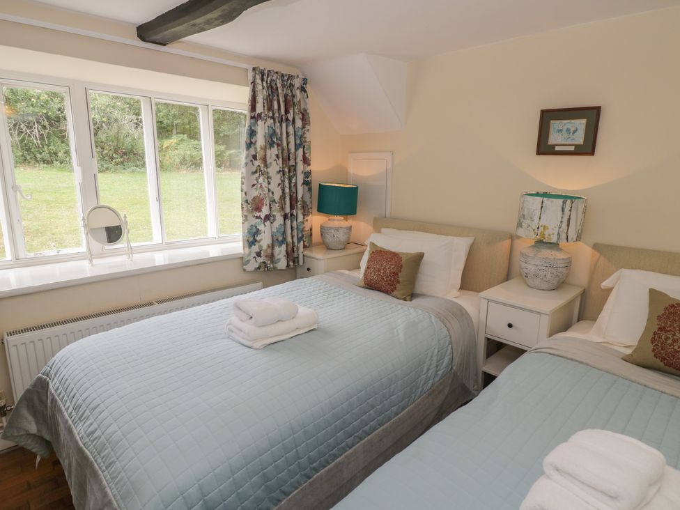 A bedroom with two beds and a window at Hillside Cottage 