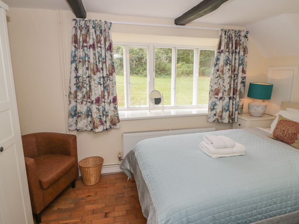 A bedroom with a bed and window at Hillside Cottage