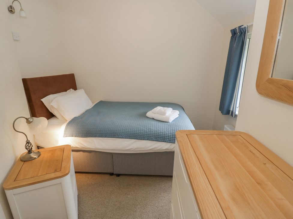 A bedroom with a bed and a dresser at Hillside Cottage