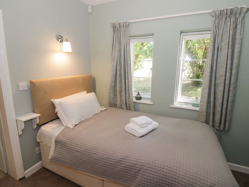 A bedroom with a bed and bedside lamp at Boxbush Lodge Monmouth