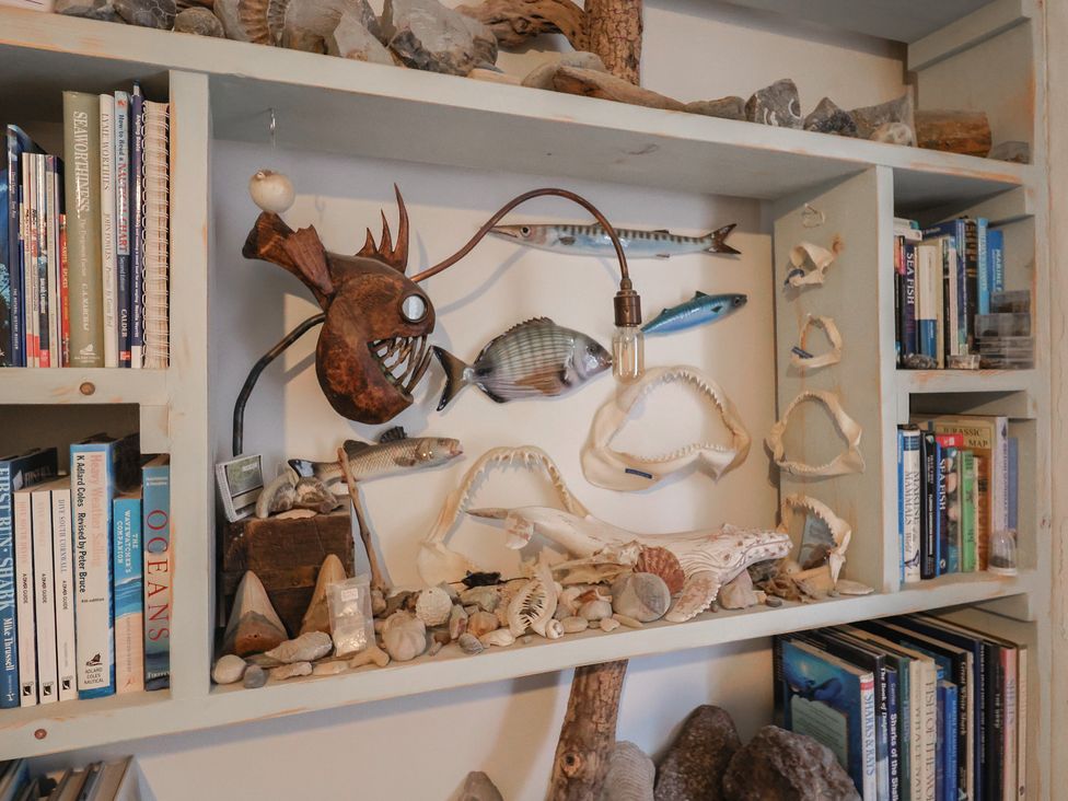 A shelf with books and decorative items at 5B Bridge Street Lyme Regis