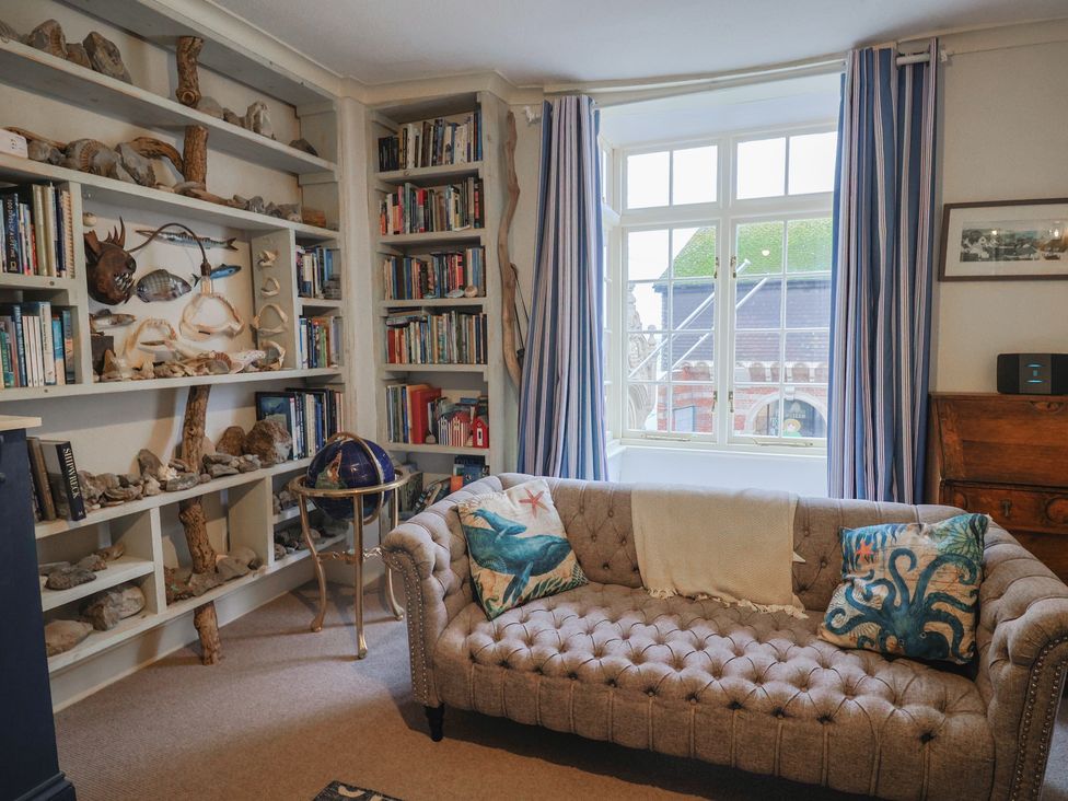 A living room with a bookshelf and a sofa at 5B Bridge Street Lyme Regis