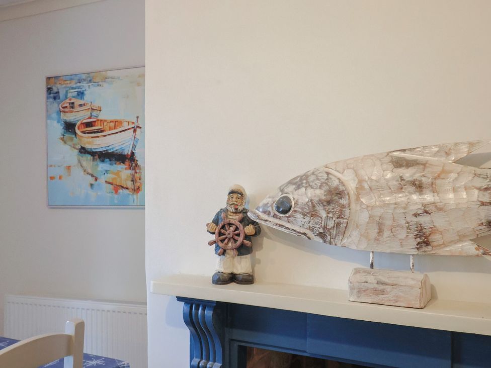 A wooden fish sculpture and figurine on a shelf at 5B Bridge Street Lyme Regis