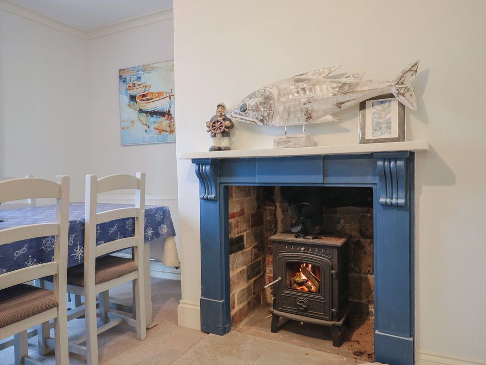 A dining room with a blue table and wood stove at 5B Bridge Street Lyme Regis