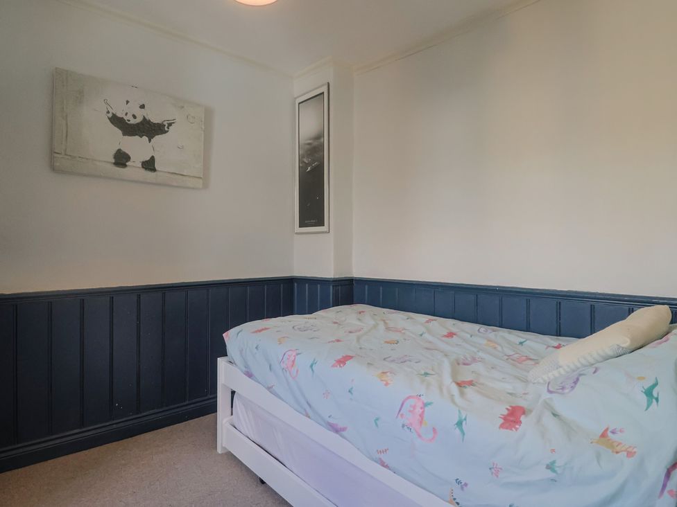 A bedroom with a bed and wall art at 5B Bridge Street in Lyme Regis