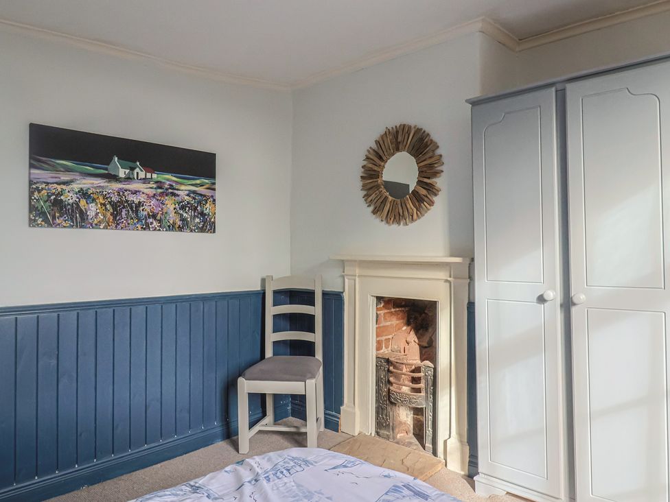A bedroom with a wardrobe and a mirror at 5B Bridge Street in Lyme Regis