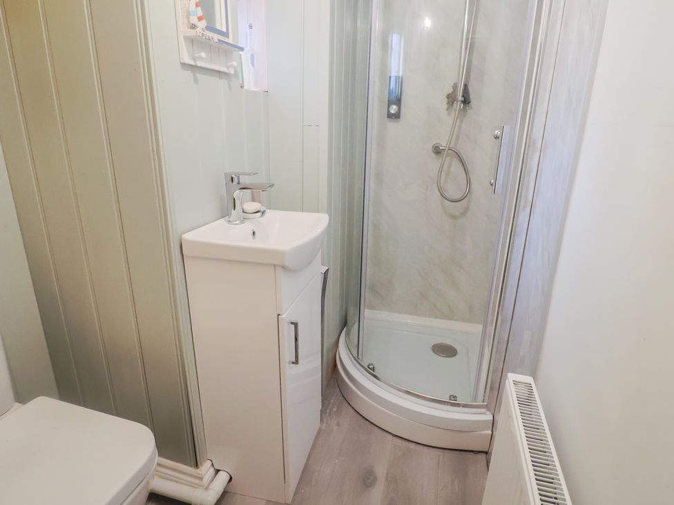 A bathroom with a shower, sink and toilet at 5B Bridge Street in Lyme Regis