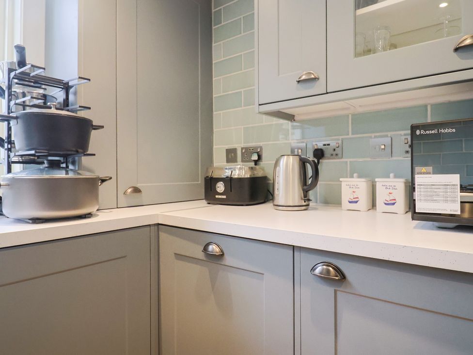 A kitchen with kettle and stacked pots at 5B Bridge Street in Lyme Regis