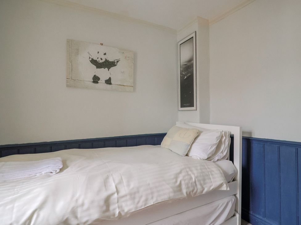 A bedroom with a bed and wall art at 5B Bridge Street in Lyme Regis