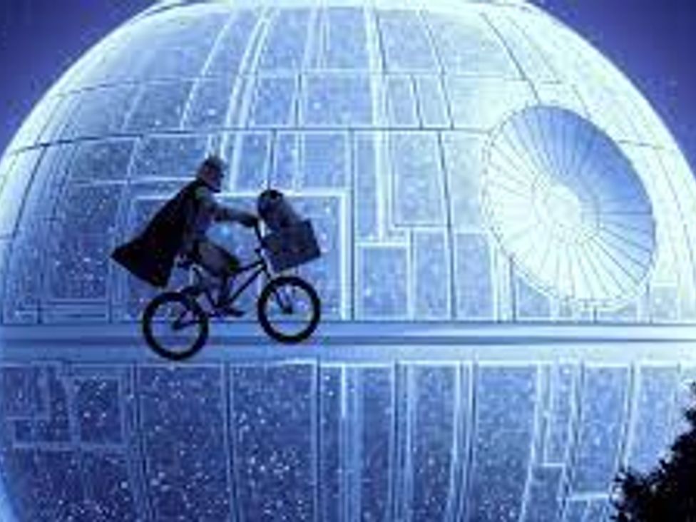 A figure riding a bicycle in front of a large spherical object in a nighttime setting